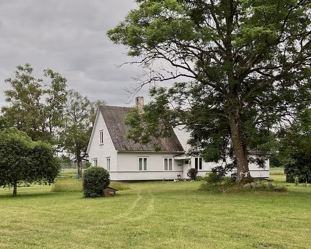 Charming countryside house with white flowers and rustic barn